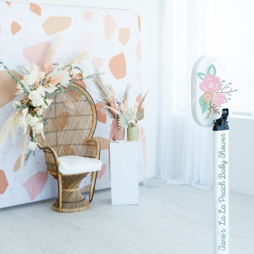 Elegant and vibrant pillow case backdrop with various pastel and earthly colored shapes. Modern wicker chair with white and peach colored flowers.